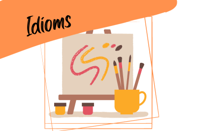 art supplies - pencils, watercolors and paint brushes, and an easel, and the word "idioms"