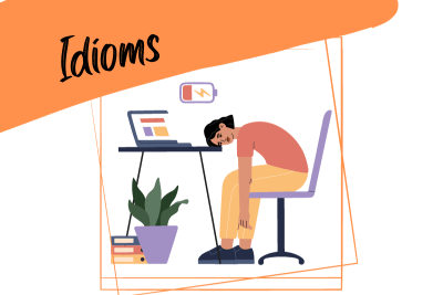 an exhausted sleepy woman tired of working hard sits next to a laptop and the word "idioms"